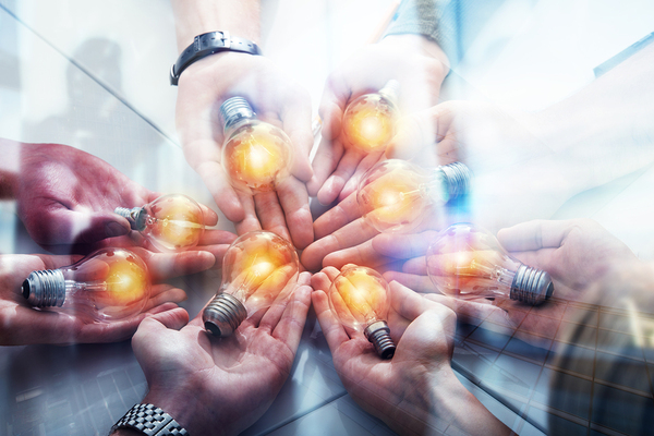 People holding lightbulbs in their palms.
